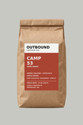 Camp 53 dark roast whole bean coffee in Outbound's oxide red label bag